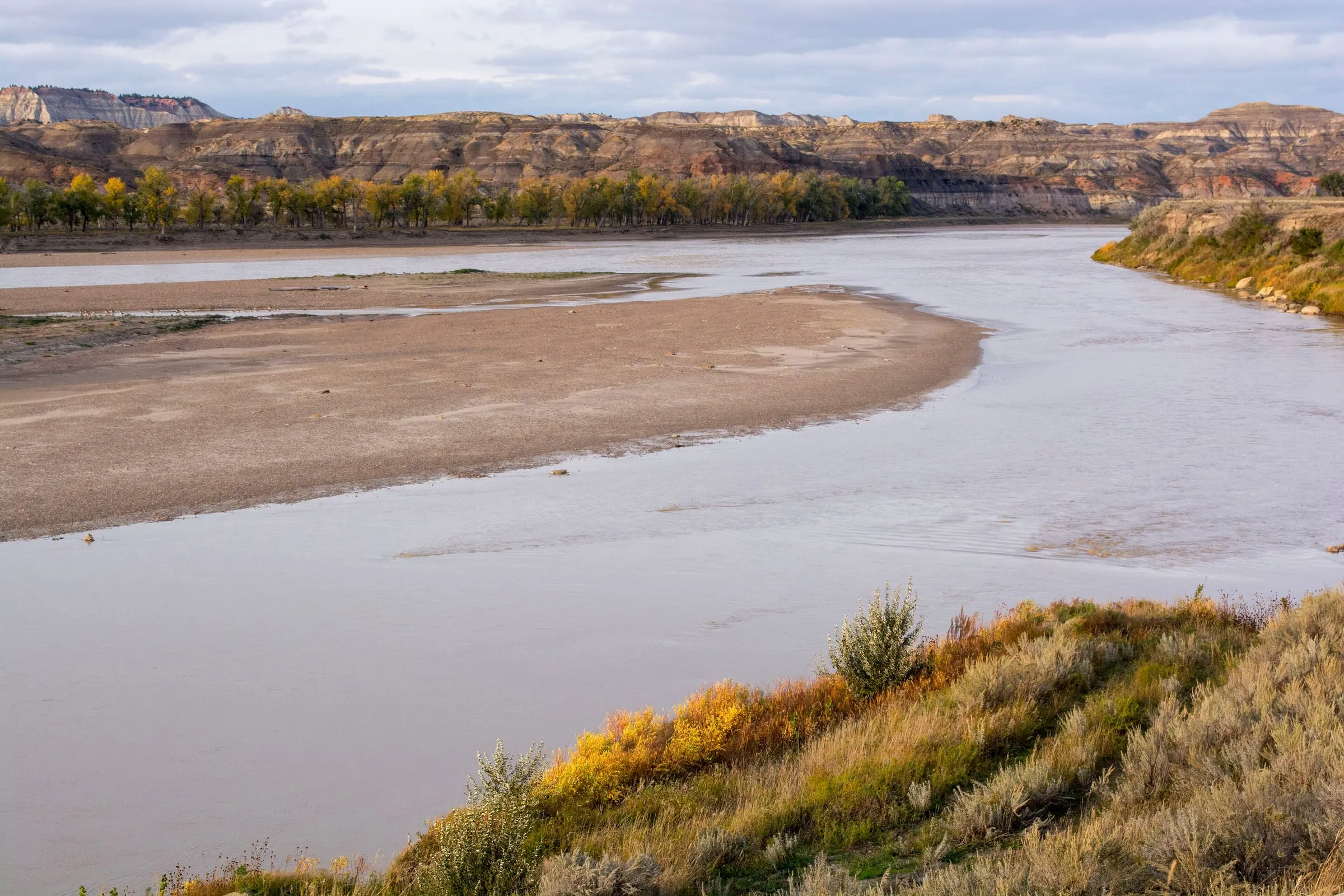 Gravel bars along a bend of the Yellowstone River, with low bluffs beyond